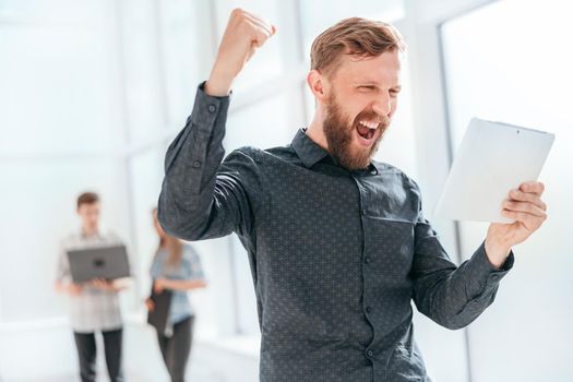 happy man reading a message on his digital tablet . photo with copy space