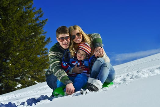 Winter season. Happy family having fun on fresh snow on vacation.