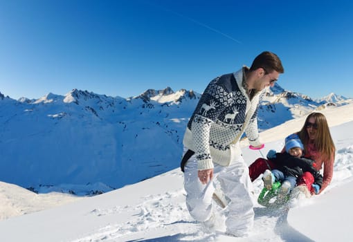 Winter season. Happy family having fun on fresh snow on vacation.