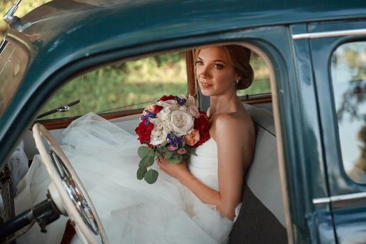 beautiful bride with wedding bouquet sitting in the car. holidays and events