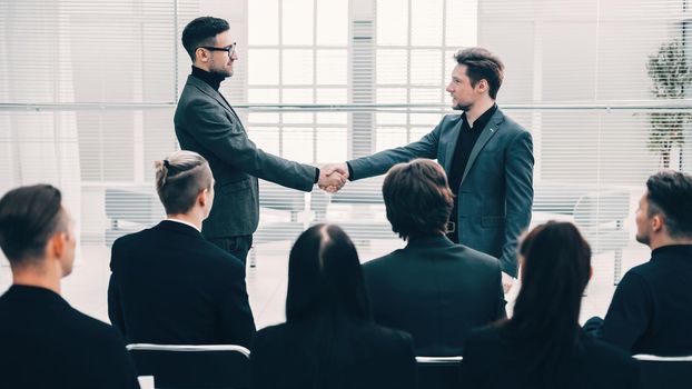happy colleagues shaking hands with each other. meetings and partnerships