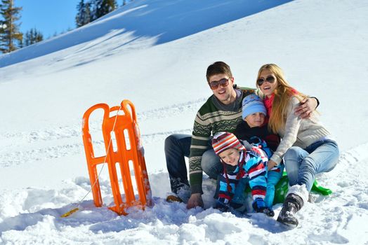 Winter season. Happy family having fun on fresh snow on vacation.