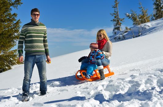 Winter season. Happy family having fun on fresh snow on vacation.