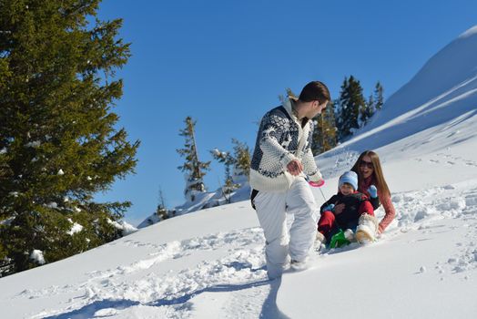 Winter season. Happy family having fun on fresh snow on vacation.