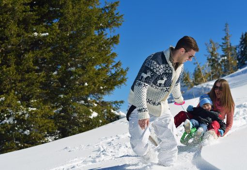 Winter season. Happy family having fun on fresh snow on vacation.