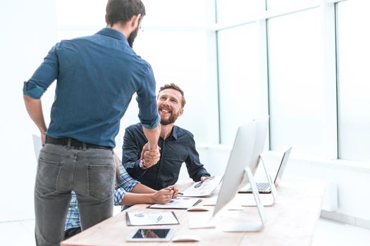 colleagues greet each other with a handshake. office weekdays