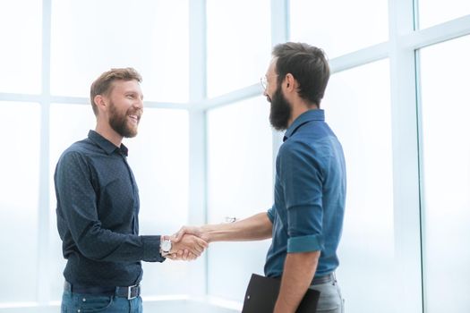 business people shaking hands in a bright office. concept of cooperation