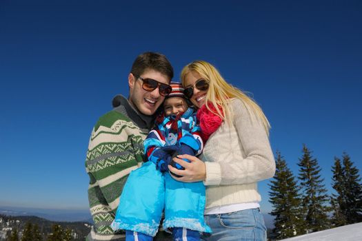 Winter season. Happy family having fun on fresh snow on vacation.