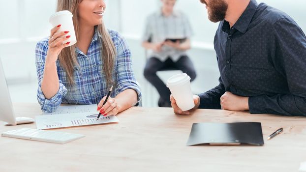 young employees discussing financial documents during coffee break. office weekdays