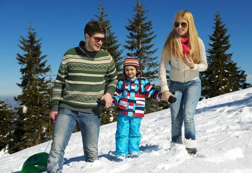 Winter season. Happy family having fun on fresh snow on vacation.