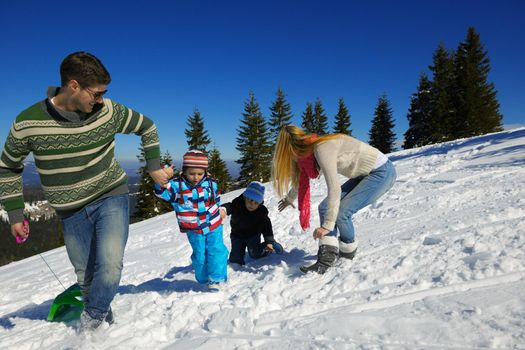 Winter season. Happy family having fun on fresh snow on vacation.