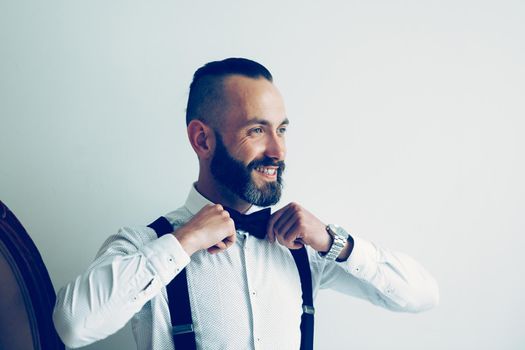close up. smiling man straightening his bow tie. photo with copy space