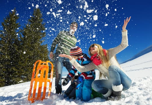 Winter season. Happy family having fun on fresh snow on vacation.