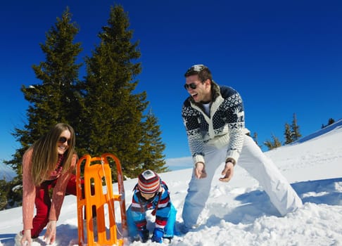 Winter season. Happy family having fun on fresh snow on vacation.