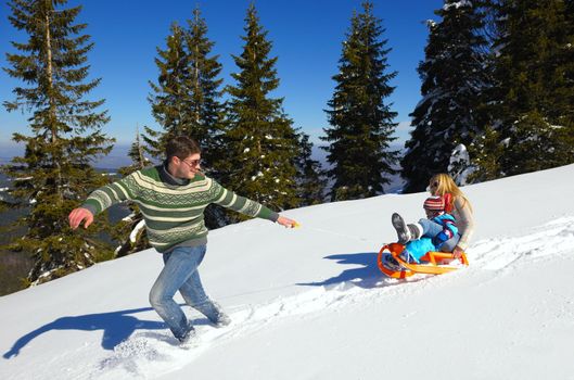 Winter season. Happy family having fun on fresh snow on vacation.