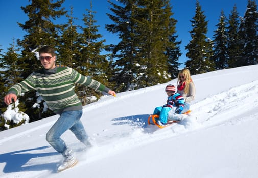 Winter season. Happy family having fun on fresh snow on vacation.