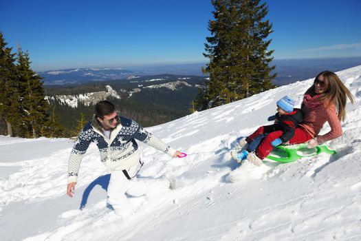 Winter season. Happy family having fun on fresh snow on vacation.