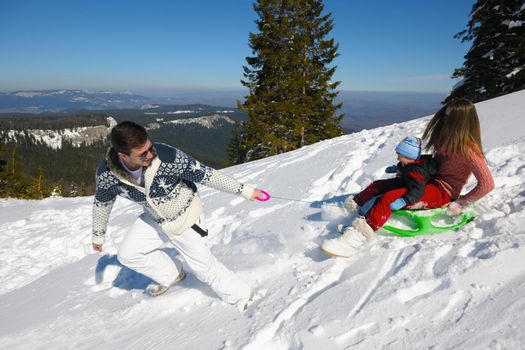 Winter season. Happy family having fun on fresh snow on vacation.