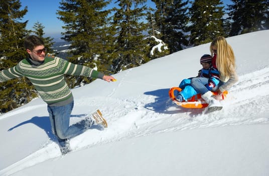 Winter season. Happy family having fun on fresh snow on vacation.