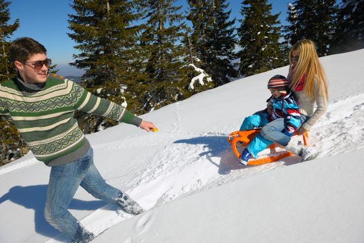 Winter season. Happy family having fun on fresh snow on vacation.