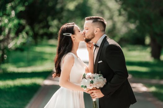 loving couple of newlyweds standing on a Park alley. events and traditions