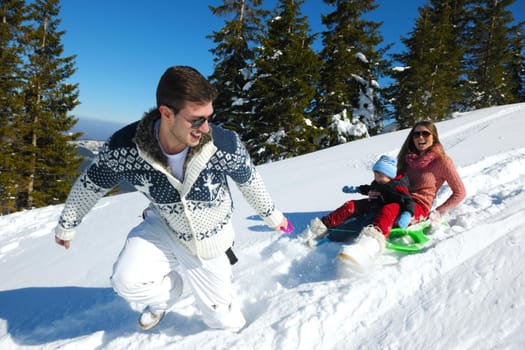 Winter season. Happy family having fun on fresh snow on vacation.