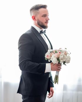 groom with wedding bouquet waiting for his bride. photo with copy space