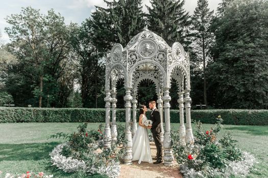 happy bride and groom standing in arched gazebo .holidays and events