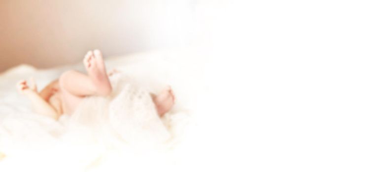 blurred image for the advertising text. image of a newborn baby lying on the couch in the nursery. photo with copy space