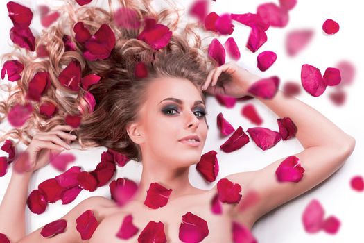 beautiful fashionable girl lying among rose petals. photo with copy space