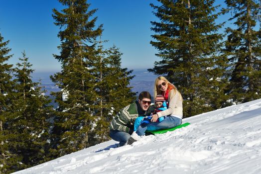 Winter season. Happy family having fun on fresh snow on vacation.