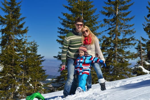 Winter season. Happy family having fun on fresh snow on vacation.