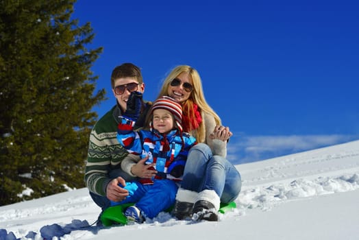 Winter season. Happy family having fun on fresh snow on vacation.