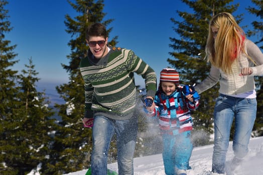 Winter season. Happy family having fun on fresh snow on vacation.