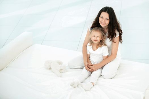 mother and daughter playing on the sofa in the living room.the concept of parenthood