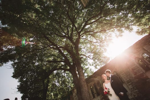 beautiful couple of newlyweds standing near an abandoned estate . bride and groom