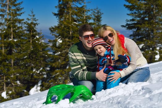 Winter season. Happy family having fun on fresh snow on vacation.