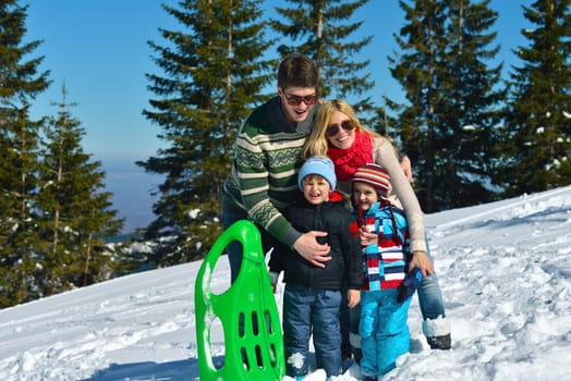 Winter season. Happy family having fun on fresh snow on vacation.