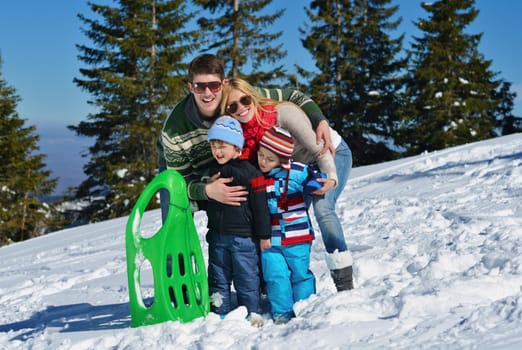 Winter season. Happy family having fun on fresh snow on vacation.