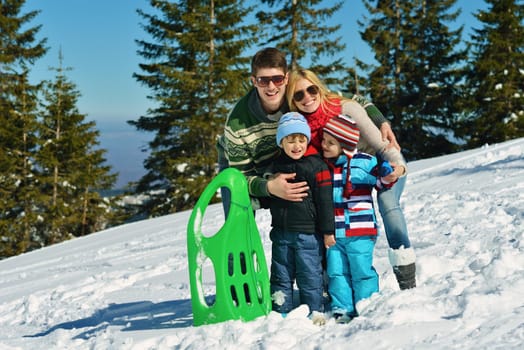 Winter season. Happy family having fun on fresh snow on vacation.