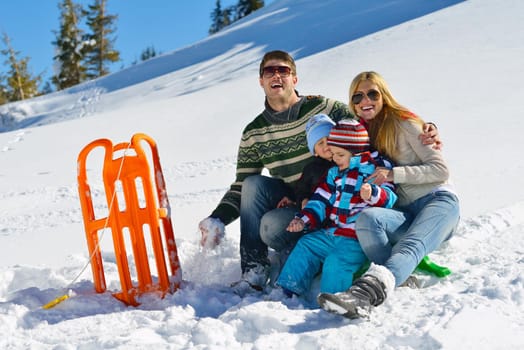 Winter season. Happy family having fun on fresh snow on vacation.