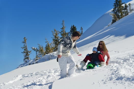 Winter season. Happy family having fun on fresh snow on vacation.