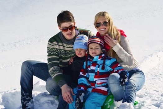 Winter season. Happy family having fun on fresh snow on vacation.