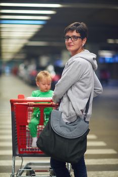 young mother with baby in shopping mall supermarket store buying food and grocery