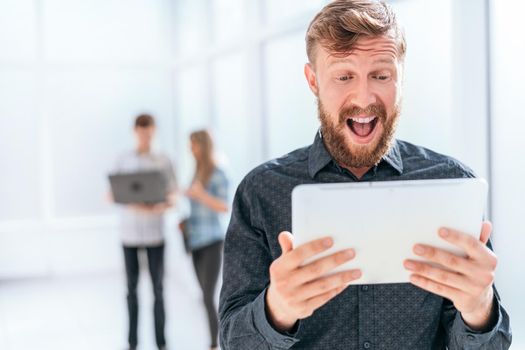 surprised businessman reading SMS on his tablet. photo with copy space