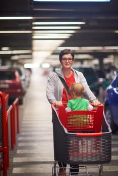 young mother with baby in shopping mall supermarket store buying food and grocery