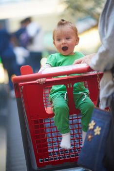 young mother with baby in shopping mall supermarket store buying food and grocery