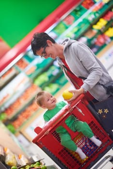 young mother with baby in shopping mall supermarket store buying food and grocery