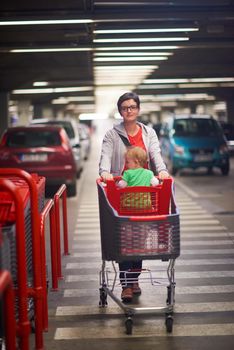 young mother with baby in shopping mall supermarket store buying food and grocery