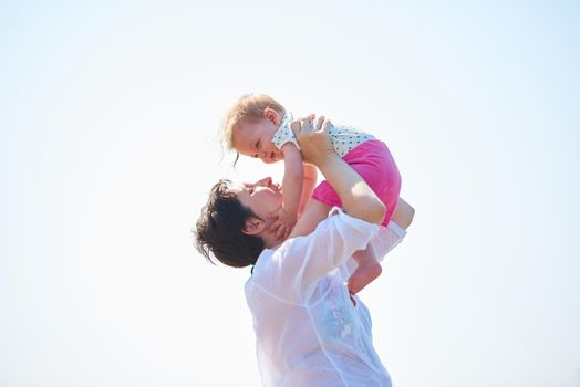 happy mom and baby on beach  have fun while learning to walk and  make first steps